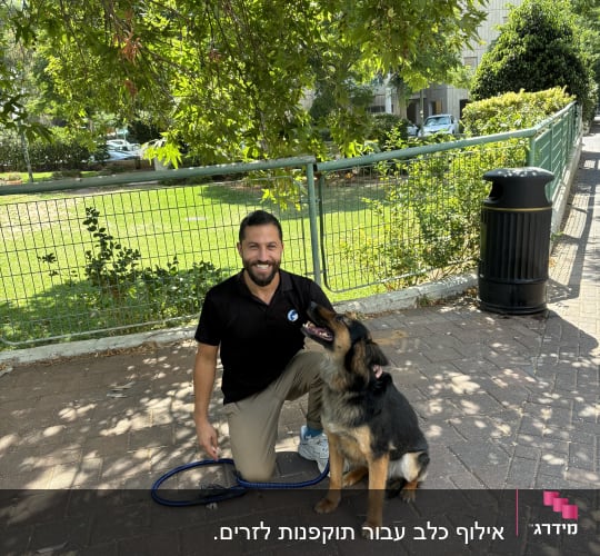 איש מאמן כלב עם רצועה כחולה בפארק